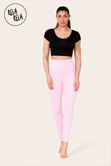 Model stretching in baby pink high waisted workout leggings, showing flexibility