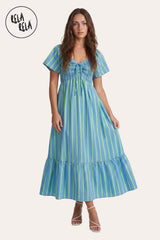 Front view of a model wearing the Blue Stripe Smocked Maxi Dress, highlighting the refreshing sky-blue vertical stripes and the romantic lace-up neckline.