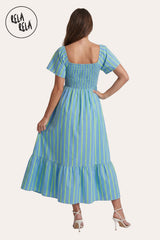 Rear view of the model in the Blue Stripe Smocked Dress, demonstrating the continuous smocking for a comfortable fit and the graceful maxi length.
