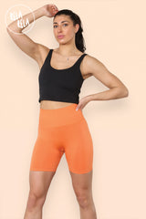 Model wearing high waisted orange scrunch bum shorts