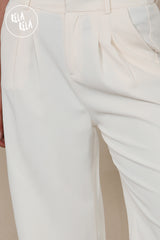 Close-up of Stretchy Fabric and tailoring details on cream wide leg trousers
