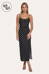 Front view of a model wearing the Black Retro Polka Dot Slit Maxi Slip Dress, highlighting the timeless noir-black hue and the minimalist scoop neckline.