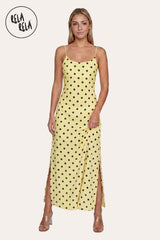 Front view of a model wearing the Yellow Retro Polka Dot Slit Maxi Slip Dress, highlighting the vibrant sunshine-yellow hue and the classic scoop neckline.