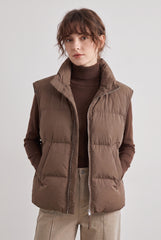 Front model view of the RELA RELA Brown padded stand collar puffer gilet, showing the sleeveless quilted shape, zip front and side pockets.