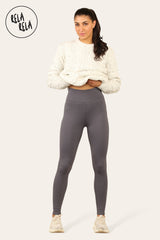 Model wearing charcoal fleece lined leggings styled with sweater and trainers