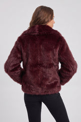 Back model view of a burgundy short faux fur jacket, showing the plush texture, broad collar, long sleeves and short hem.