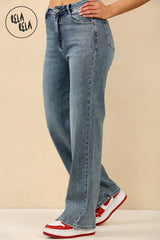 Side profile of woman walking in denim blue rhinestone embellished wide leg jeans.