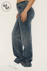 Side angle of denim blue sparkle jeans featuring mid waist and wide leg cut.