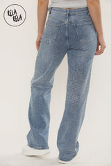 Back angle of mid blue sparkle jeans with wide leg shape and subtle rhinestones.