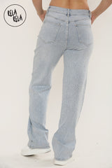 Back view of women's mid-waist light blue sparkle jeans with rhinestone embellishments.