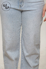 Close-up of rhinestone scatter detailing on light blue sparkle wide leg jeans.