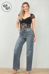 Model wearing mid waist rhinestone jeans in denim blue, front angle