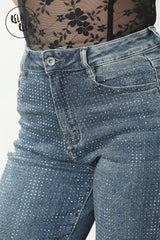 Close-up of mid waist waistband on denim jeans with rhinestone in denim blue