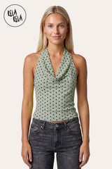Front view of a model in Rela Rela’s Sage Green Draped Polka Dot Mesh Halter Top, showcasing the elegant cowl neck drape and the soft botanical green texture in a summer-ready outfit.