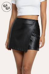 Front view of black faux leather wrap front skorts with asymmetric design