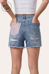 Back view of the model wearing the Light Blue Shorts, demonstrating the statement pink rhinestone back pocket and the sculpting fit.