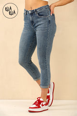 Side view of denim blue petite cropped skinny jeans, showing 3/4 length and mid rise design.