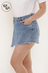Side angle of asymmetric blue denim skorts with front buttons