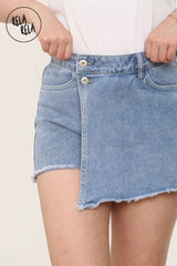 Close-up of Flat lay of asymmetric blue denim skort showing wrap design and stretchy mid-rise waistband