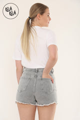 Back view showing the grey stretchy denim skort with back pockets and frayed hem