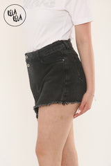 Side angle of asymmetric black denim skort styled with a white tee
