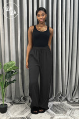 Casual styling with black plissé trousers and strap vest – versatile pleated trouser pants for everyday wear.