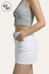 Side profile of the belted micro denim skirt in White, showing the high-stretch fabric's body-con fit and the clean, monochromatic silhouette.