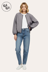 Model wearing oversized grey zip-up bomber jacket, casual street style