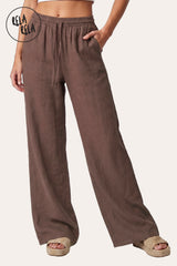 Front view of a model in Rela Rela’s Brown high-waisted linen trousers, highlighting the rich cocoa tone and the sophisticated wide-leg drape.