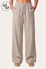 Front view of a model in Rela Rela’s Cream high-waisted linen trousers. Highlights the clean wide-leg silhouette and the adjustable drawstring waist detail.