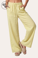Front view of a model in Rela Rela’s Yellow high-waisted linen trousers, showcasing the vibrant sunshine hue and the relaxed wide-leg cut.