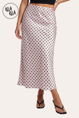 Front view of a model wearing Rela Rela Pink satin polka dot flowy maxi skirt. Highlights the high-waisted fit and the elegant, shimmering satin fabric.