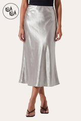 Front view of a model wearing Rela Rela’s Silver satin maxi skirt with a slim straight cut. Highlights the elegant high-waisted fit and the lustrous, silky finish of the premium satin fabric.