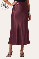 Front view of a model wearing Rela Rela’s Plum satin maxi skirt with a slim straight cut. Highlights the elegant high-waisted fit and the lustrous, silky finish of the premium satin fabric.