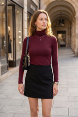 Model wearing the RELA RELA burgundy slim fit roll neck long sleeve top with a black mini skirt for a city outfit.