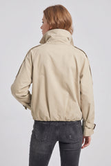 Back model view of a beige cropped trench jacket, showing the raised collar, shoulder-tab details, long sleeves and gathered hem.