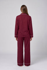 Back model view of a burgundy two-piece pyjama set showing the collar piping, long sleeve shirt, cuff trim and full-length matching trousers.