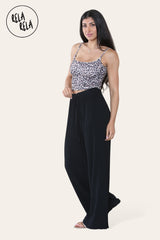 Model wearing black plissé trousers side view – elegant trousers with pleats and relaxed fit.