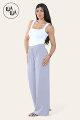 Model wearing grey plissé trousers side view – elegant trousers with pleats and relaxed fit.