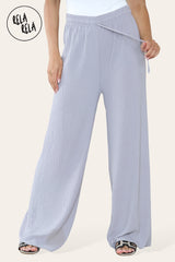 Close-up of grey plissé fabric – detailed texture of pleated wide leg trousers.