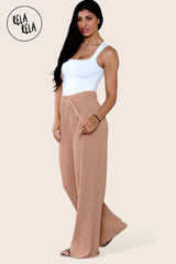 Model wearing tan plissé trousers side view – elegant trousers with pleats and relaxed fit.