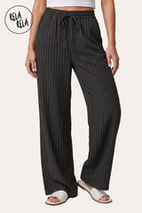 Front view of a model wearing RELA RELA Black pinstripe relaxed-fit trousers, with an elasticated high-rise waistband, side pockets and a full-length wide-leg drape on a clean white backdrop.