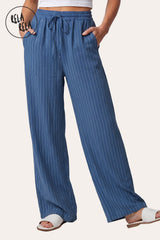 Front view of a model wearing RELA RELA Navy pinstripe relaxed-fit trousers, with an elasticated high-rise waistband, side pockets and a full-length wide-leg drape on a clean white backdrop.