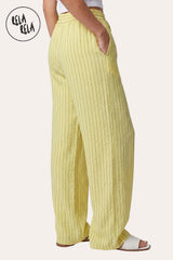 Side view of a model wearing RELA RELA Yellow pinstripe relaxed-fit trousers, showing the relaxed wide-leg silhouette from hip to ankle.
