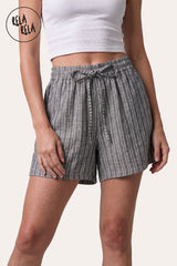 Front view of a model wearing Rela Rela's Grey vertical striped flowy loungewear shorts. Highlights the stretchy elastic waistband, faux linen fabric, and the relaxed flowy silhouette.