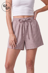 Front view of a model wearing Rela Rela's Pink vertical striped flowy loungewear shorts. Highlights the stretchy elastic waistband, faux linen fabric, and the relaxed flowy silhouette.