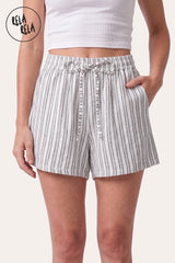 Front view of a model wearing Rela Rela's White vertical striped flowy loungewear shorts. Highlights the stretchy elastic waistband, faux linen fabric, and the relaxed flowy silhouette.