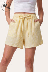 Front view of a model wearing Rela Rela's Lemon vertical striped flowy loungewear shorts. Highlights the stretchy elastic waistband, faux linen fabric, and the relaxed flowy silhouette.