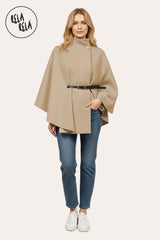 Model wearing camel belted high neck poncho cape jacket paired with jeans.