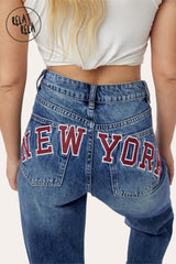 Close-up of New York embroidery on blue denim wide leg jeans